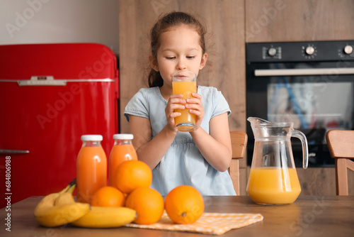 Little girl drinking orange...