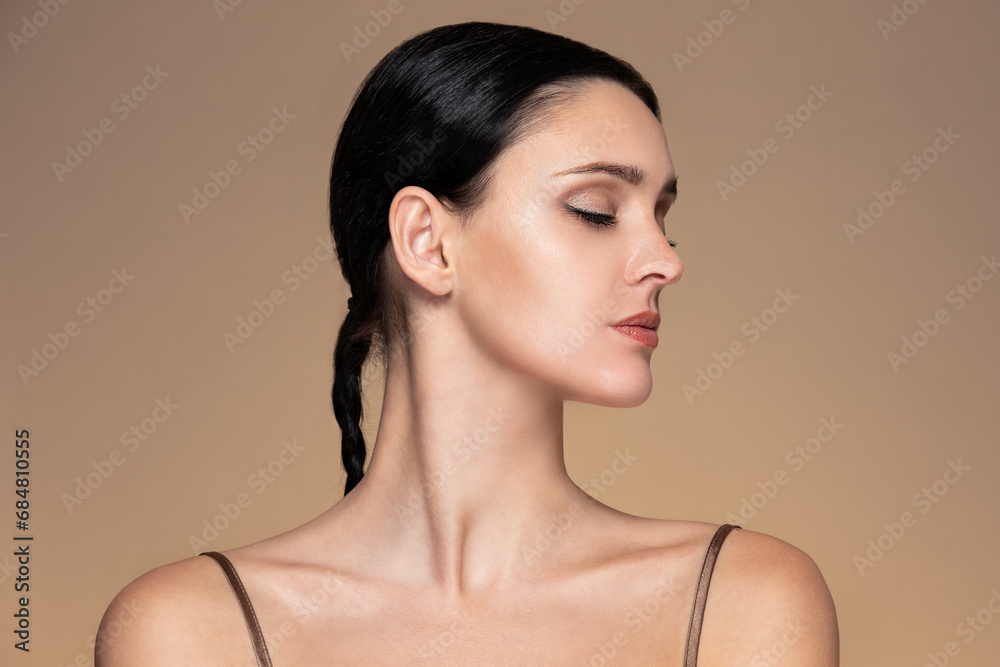 Beauty studio portrait of young beautiful woman with closed eyes against beige background Beauty studio portrait of young beautiful woman with closed eyes against beige background