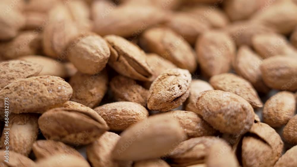 Delicious roasted almond nuts with nutshell crack falling in slow motion. Christmas treats. Rotation Delicious roasted almond nuts with nutshell crack falling in slow motion. Christmas treats. Rotation