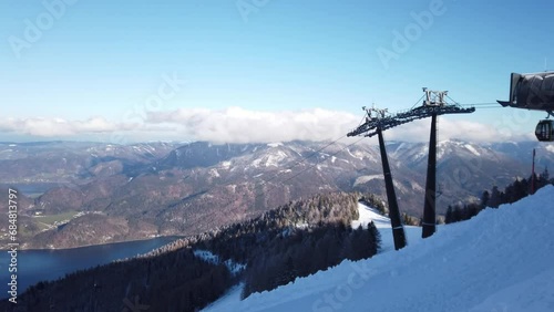 DOLLY SHOT - The Cabine Zwolferhorn cable car. Cable car or telecabin in Sankt St. Gilgen village, starting from the town and up to Das Zwolfer station, Austria. photo