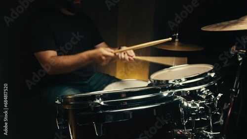 Expressive drummer young man professionally playing on dums in studio room close-up. Rock metall music artist  photo