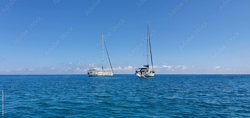 Sailboats on the clear blue sea with scenic horizon 