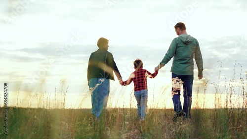Family enjoys walk in field basking in joyous moments brought by windy weather
