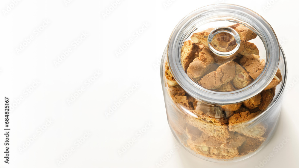 Top view of a glass jar filled with rusks, isolated on white copy-space background.