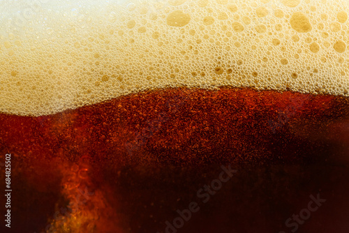 Dark beer with foam as background photo