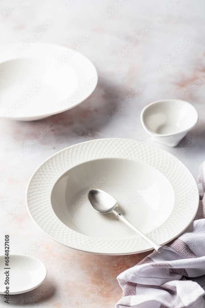 Set of soup plates and dinnerware on white marble background