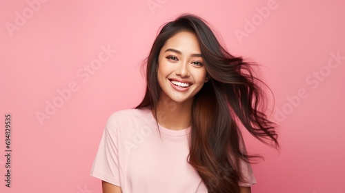young filipino woman, happy smiling into camera, pink background, soft, vibrant, energetic, copy space, 16:9