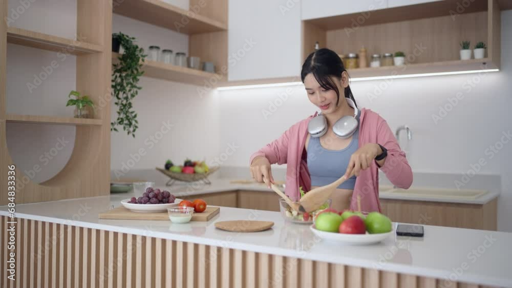 Happy young asian woman standing in kitchen and cooking vegetable salad, Vegan Dieting Concept Happy young asian woman standing in kitchen and cooking vegetable salad, Vegan Dieting Concept