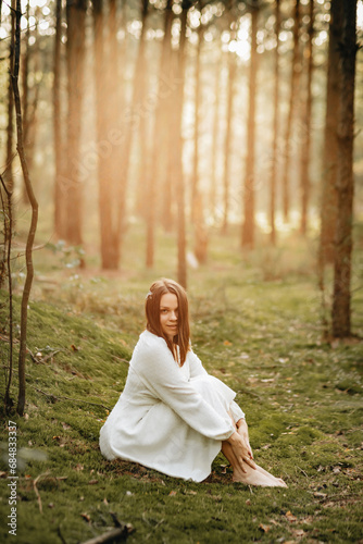 a young girl in a white dress in a green pine tree the forest