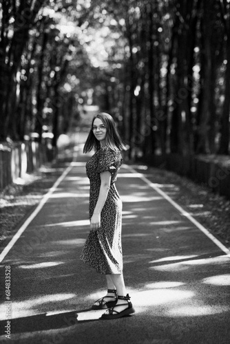 a girl in a dress walks along a beautiful road in the forest