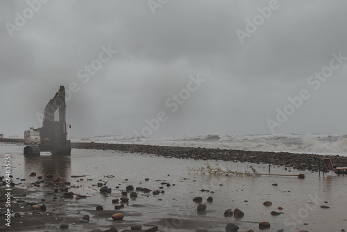 An excavator drives along an embankment destroyed after a storm on the shores of the Black Sea. photo