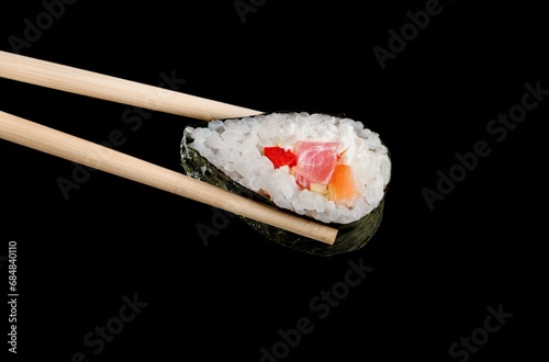 Tasty fresh sushi in wooden chopsticks