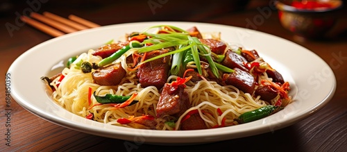 Indonesian and Malay style fried noodles made with rice vermicelli, sausage, chili, and green onion. © 2rogan