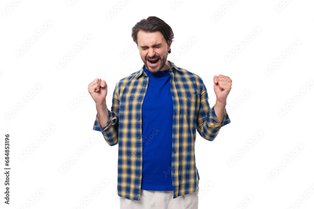 Naklejka premium happy brunette brutal man with a beard in a plaid shirt rejoices in good luck