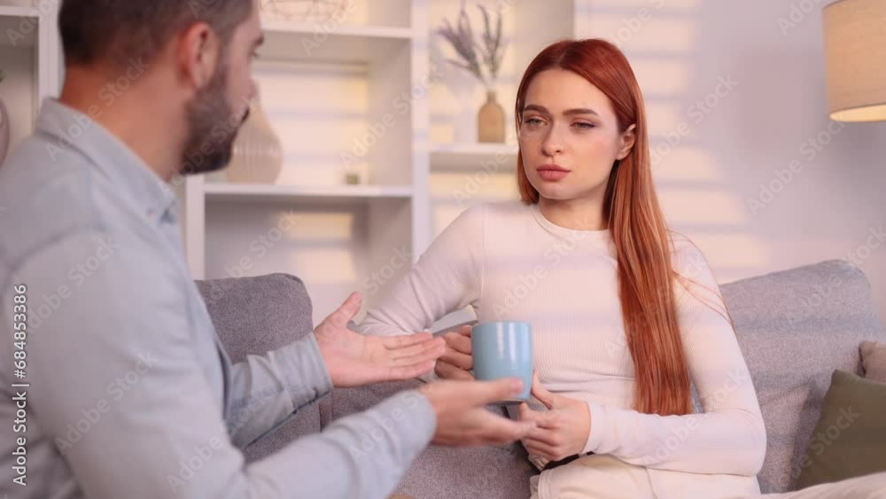 Smiling young couple talking sharing news after hard working day at cozy home Happy people enjoying spending time together sitting on couch indoors Smiling young couple talking sharing news after hard working day at cozy home Happy people enjoying spending time together sitting on couch indoors