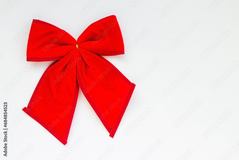 Christmas bow made of red fabric on white surface with copy space Christmas bow made of red fabric on white surface with copy space