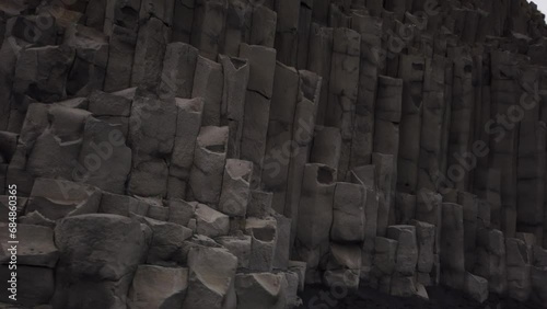 DOLLY SHOT - The Reynisfjara Black sand beach, Halsanefshellir cave, basalt columns, and sea stacks at Vik i Myrdal in Iceland.