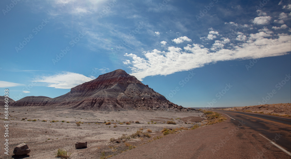 Streaking clouds over Petrified Forest National Park arid desert landscape in Arizona United States