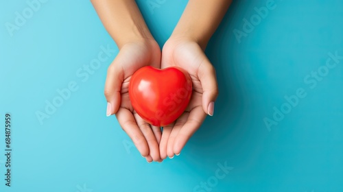 Heart held by woman's hands on colorful background. World health day