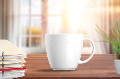 coffee cup on desk  note book by window