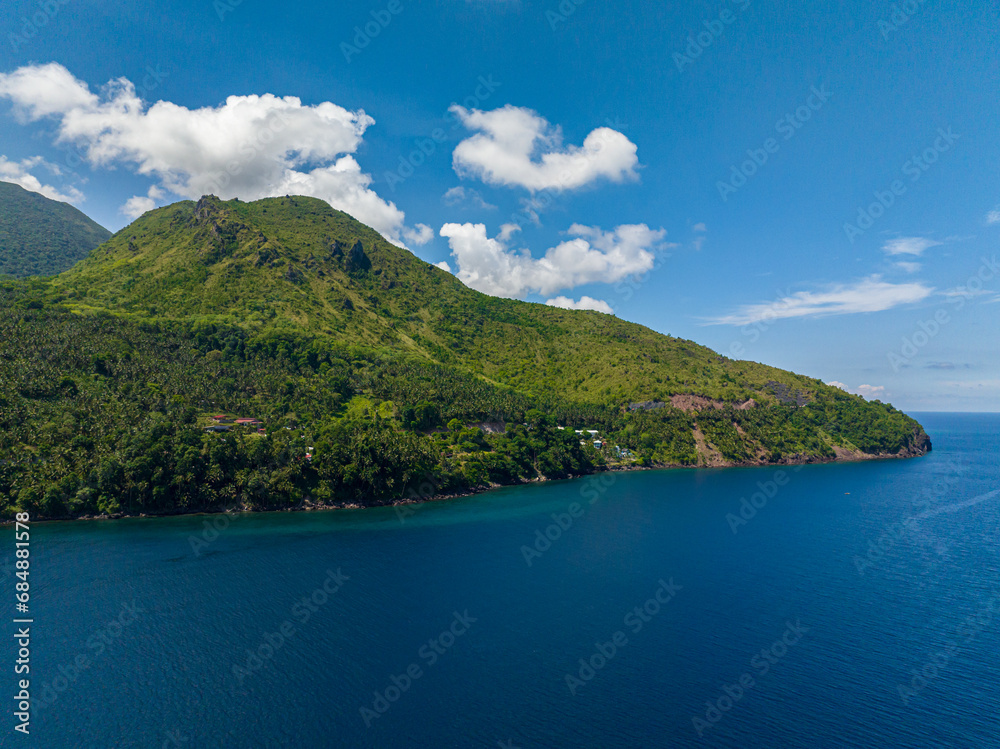 Mountain cliff near the coast. Blue sea in Camiguin Island. Philippines.