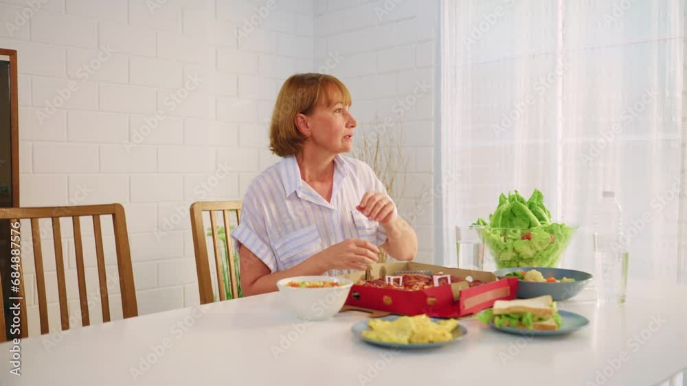 Caucasian senior woman using phone call and waiting family for dinner. Caucasian senior woman using phone call and waiting family for dinner.