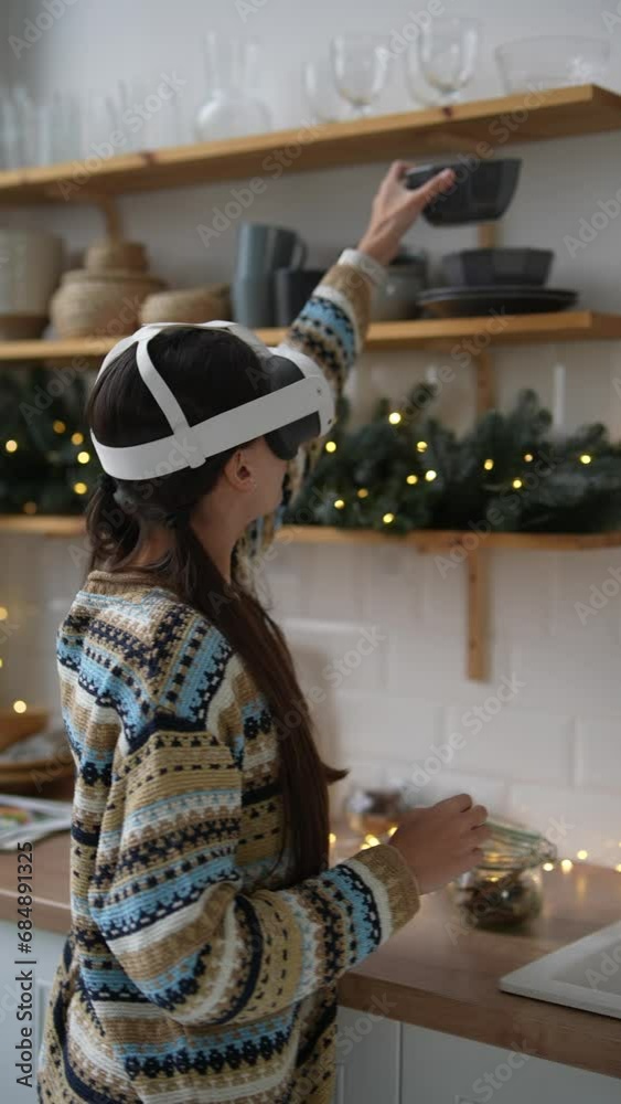 Using a virtual reality headset, a stylish young woman prepares food during the Christmas period. Using a virtual reality headset, a stylish young woman prepares food during the Christmas period.