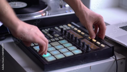 man in the home music studio, creating new song, making sound production with drum machine