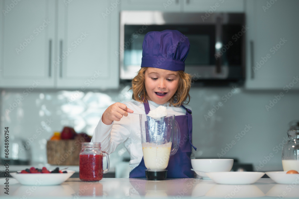 Child chef cooking meal. Kid chef cook wearing uniform cook cap and apron cooked food in the kitchen. Child chef cooking meal. Kid chef cook wearing uniform cook cap and apron cooked food in the kitchen.
