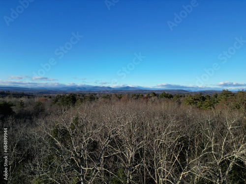bare winter trees  view of mountains  fall  next to evergreen conifers  aerial view  drone shot  from above  forest  hiking  nature  deciduous woods  northeast  wilderness  wild  wood  tree  clear day