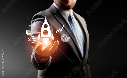 Businessman holding rocket icons in hand