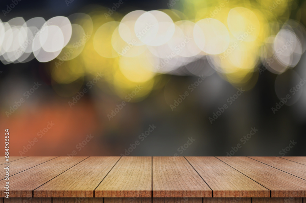 Empty wooden table top with lights bokeh on blur restaurant background.