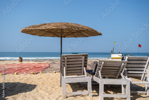 Fototapeta Naklejka Na Ścianę i Meble -  wooden beach umbrellas and sunbeds loungers on sandy beach of ocean