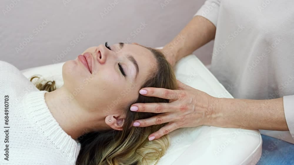 Healer woman performing by lightly touched access bars therapy on young woman head, stimulating positive change thoughts and emotions. Alternative medicine concept Healer woman performing by lightly touched access bars therapy on young woman head, stimulating positive change thoughts and emotions. Alternative medicine concept