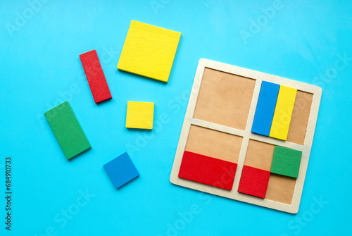 Educational toys  Cognitive skills  kid development logical thinking concept. Colorful geometric shapes toys over a blue background.Sorter for different shapes and color.