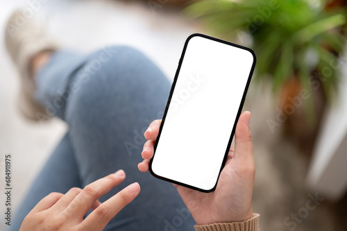 A woman using her smartphone while relaxing indoors, A white-screen smartphone mockup