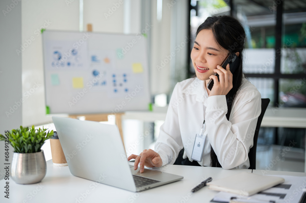 Businesswoman having a phone call with her customer while working in the office room. Businesswoman having a phone call with her customer while working in the office room.
