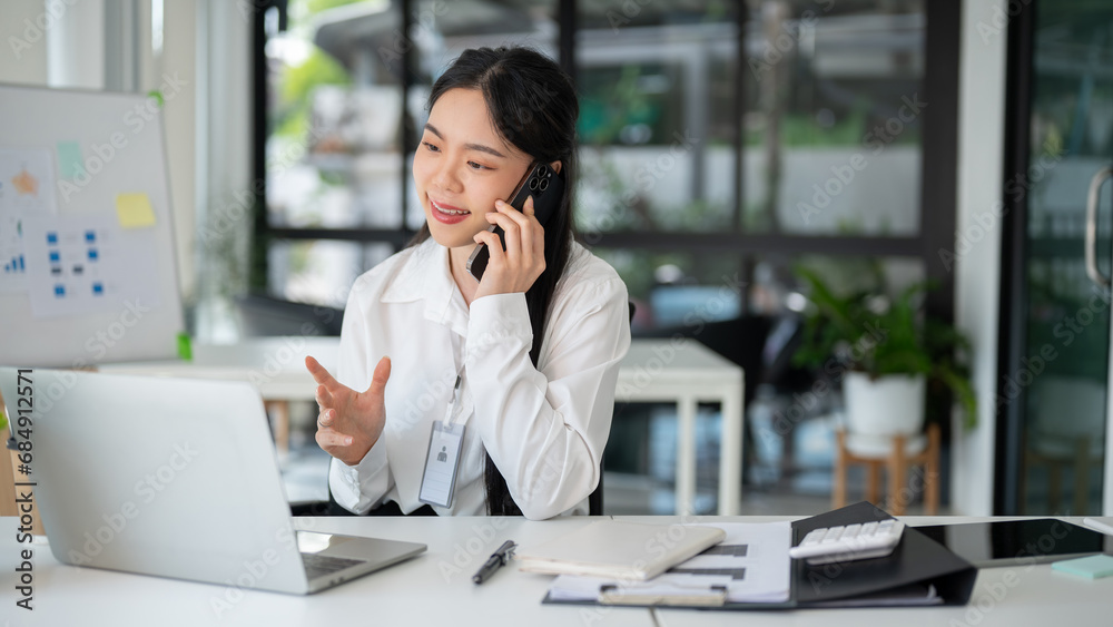 Businesswoman having a phone call with her customer while working in the office room. Businesswoman having a phone call with her customer while working in the office room.