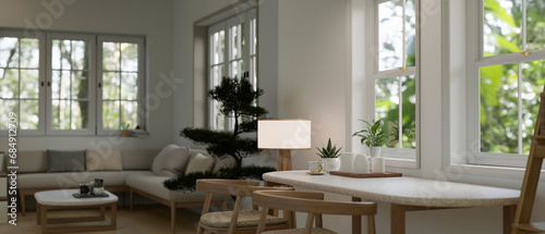 A minimal dining table against the window in a beautiful cosy Scandinavian living room.