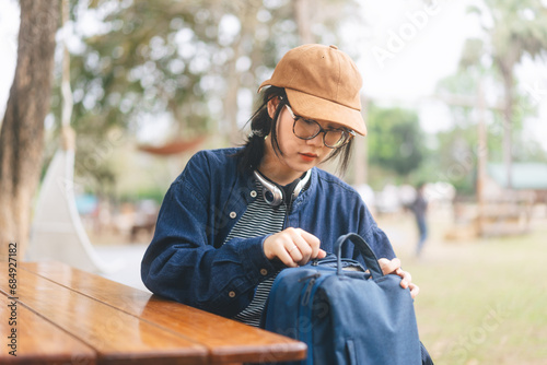 At camping area asian woman sitting on outdoor table open bag photo