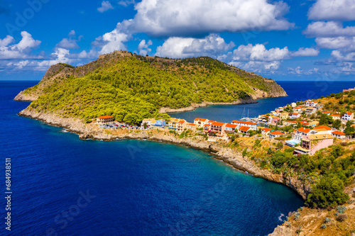 Turquoise colored bay in Mediterranean sea with beautiful colorful houses in Assos village in Kefalonia, Greece. Town of Assos with colorful houses on the mediterranean sea, Greece.