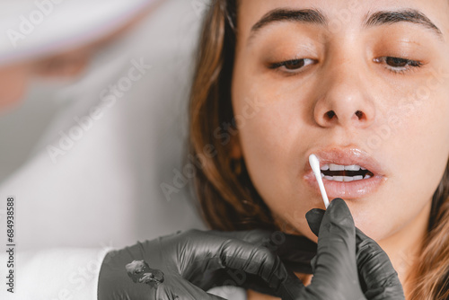 Tablou pe pânză Doctor hydrating the woman's lips after a Botox injection