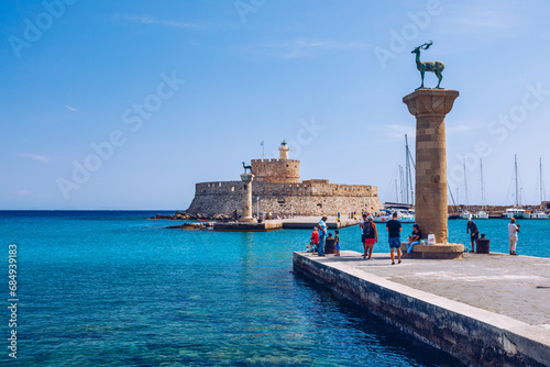 Mandraki port with deers statue, where The Colossus was standing and fort of St. Nicholas. Rhodes, Greece. Hirschkuh statue in the place of the Colossus of Rhodes, Rhodes, Greece photo