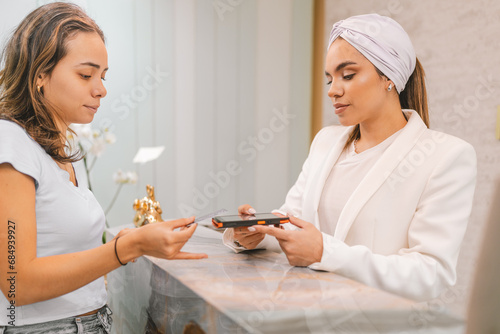 Woman paying with credit card on a beauty clinic photo