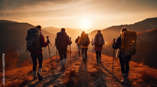 Unrecognizable group of healthy people exercising trekking in national park walking up to mountain with flower glasses field on the walking road  happy tourists lifestyle outdoor  widow sunset light