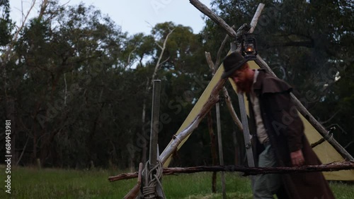 Bushman hangs up a kerosene lantarn by his historical pioneer hut in the bush. photo