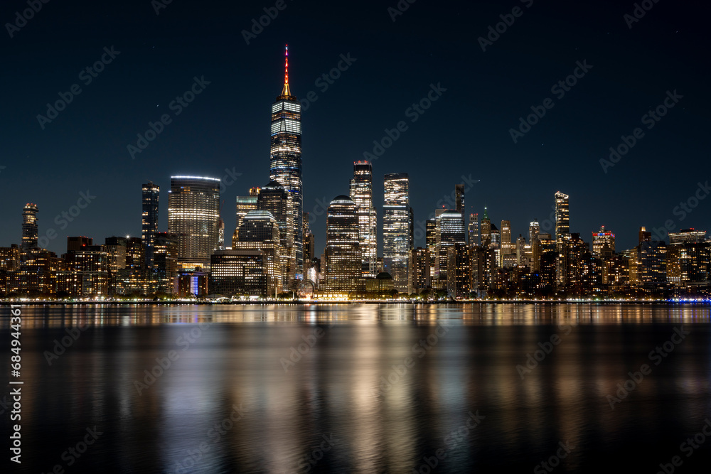 Obraz premium Manhattan Skyline at night with beautiful reflection in the hudson river in the front
