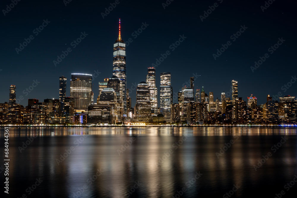 Manhattan Skyline at night with beautiful reflection in the hudson river in the front