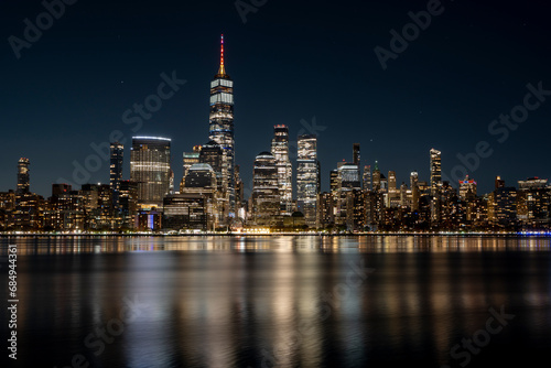 Manhattan Skyline at night with beautiful reflection in the hudson river in the front