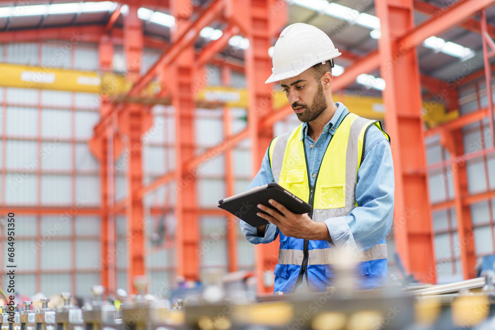 Professional Asian industrial engineer inspecting a heavy machine in metal sheet manufacturing factory. Professional Asian industrial engineer inspecting a heavy machine in metal sheet manufacturing factory.